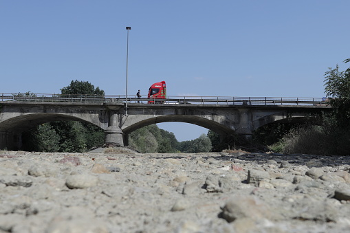 Italy, Piemonte: the river Sangone is disappeared. On the bridge two different means of transports are crossing