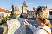 Young woman solo traveler looking at city map