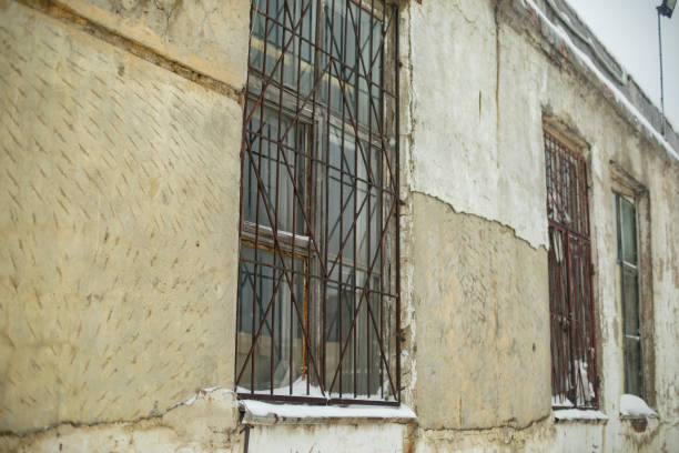 Window with grille. Old building. Steel bars on window. Industrial building in Russia.