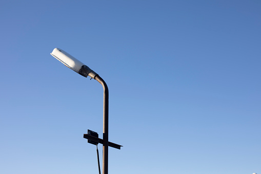 Old phanar against sky. Pole with lamp. Light system.