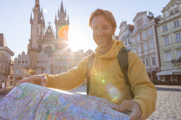 istock Young man solo traveler looking at city map 1404229072