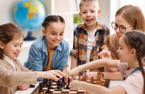 istock Woman teaching kids to play chess 1404231932