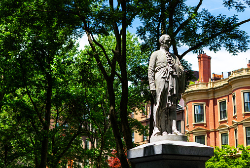 Boston, Massachusetts, USA - June 18, 2022: A granite statue of Alexander Hamilton by William Rimmer installed along Commonwealth Avenue, between Arlington and Berkeley Streets in Boston's Back Bay neighborhood. Statue created in 1864 - 1865. Alexander Hamilton (January 11, 1755 or 1757 - July 12, 1804) was an American revolutionary, statesman and Founding Father of the United States.