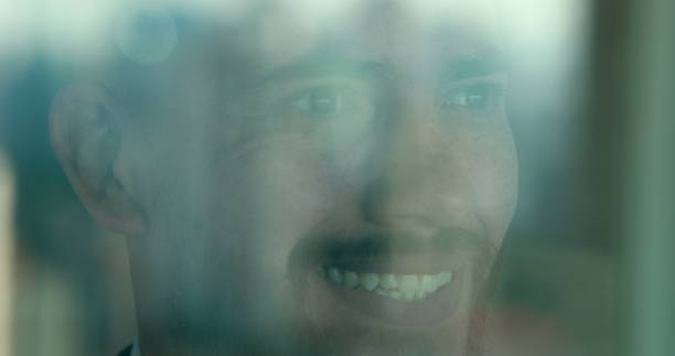 Man looking out of window at rainy day.