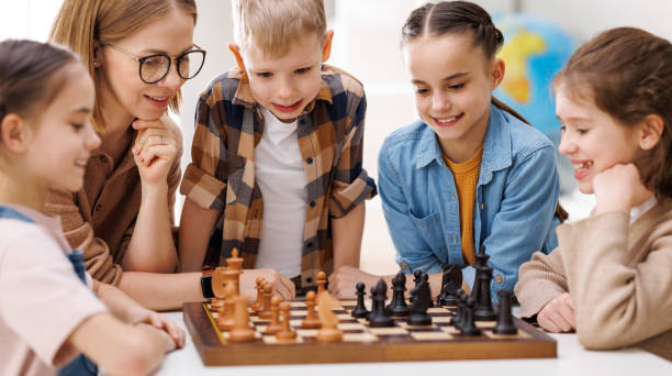 istock Woman teaching kids to play chess 1404232707