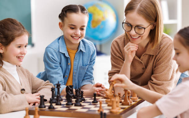 istock Woman teaching kids to play chess 1404233337