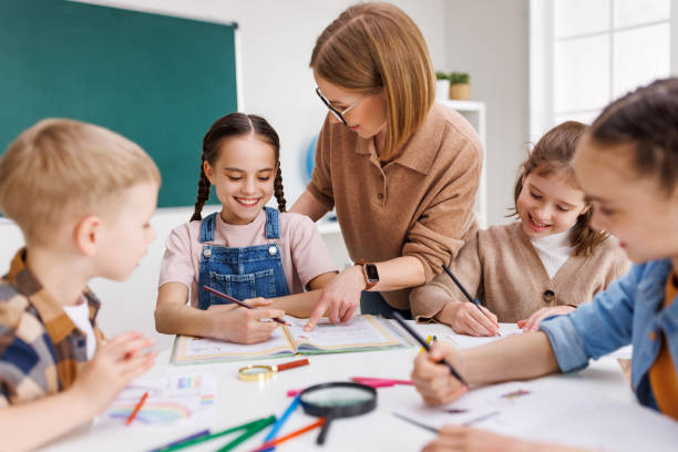 istock Teacher helping children with schoolwork 1404233960