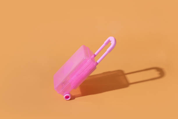 istock Toy suitcase on an orange background with a hard shadow 1404234761