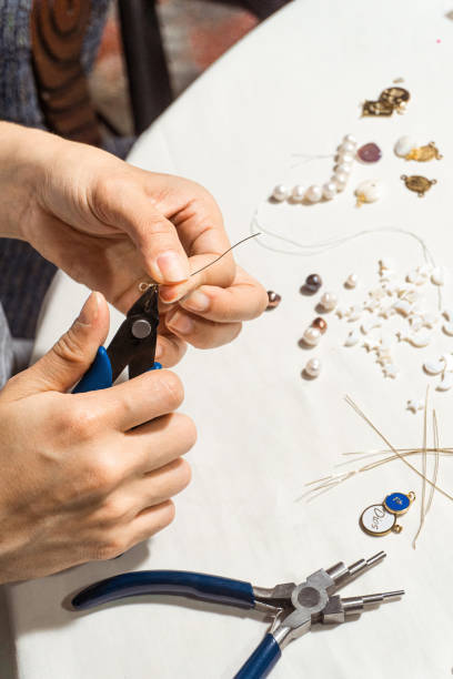 istock Hands using flat cutting pliers. homemade jewelry concept 1404235457