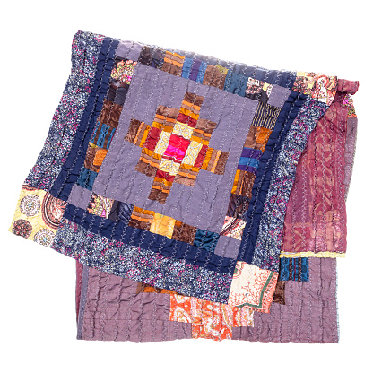 folded handcrafted patchwork scarf from purple silk fabrics cutout on white background