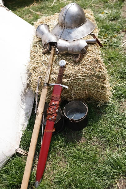 Reconsruction medieval age. Sword, helmet and gauntlet in field camp.