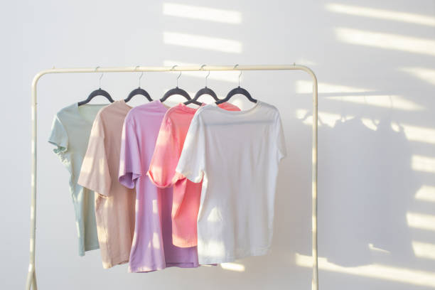 istock women's t-shirts on  hanger on  white background 1404239117