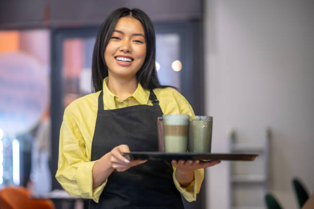 istock Woman with tray smiling at camera standing in cafe 1404239127