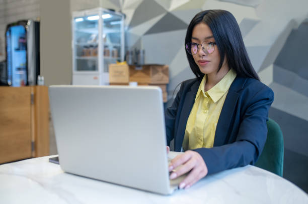 istock Woman looking at laptop sitting in office 1404239201