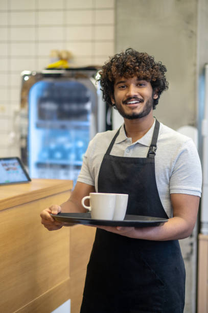 istock Man holding cups on tray smiling at camera 1404239207