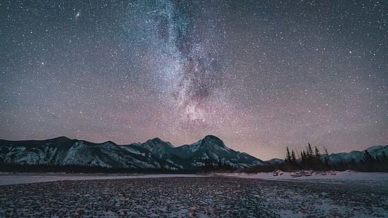 An image of the Milky Way with many stars above a mountain range in Alberta Canada near Jasper