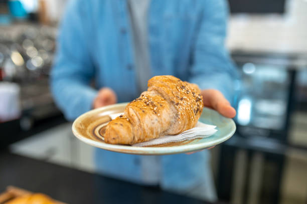 istock Male hands holding out croissant to camera 1404243025