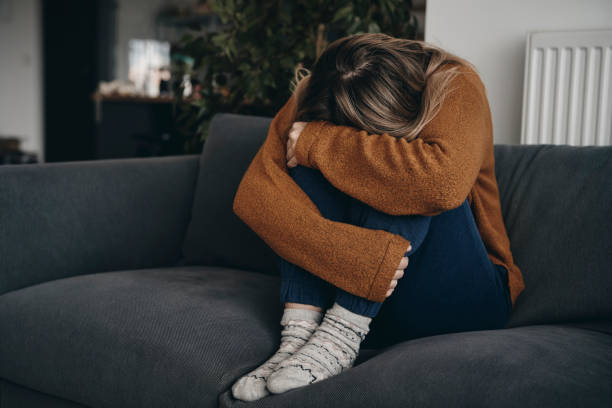 istock Sad Woman Sitting On Sofa At Home 1404245327