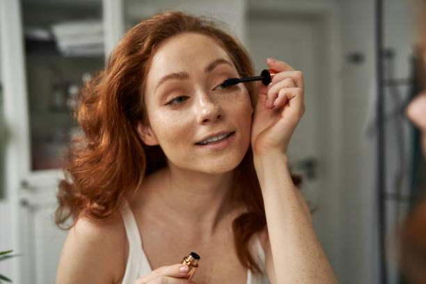 Young Woman Applying Makeup At Home stock photo
