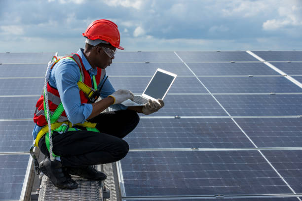 Engineer working setup Solar panel at the roof top. Engineer or worker work on solar panels or solar cells on the roof of business building stock photo