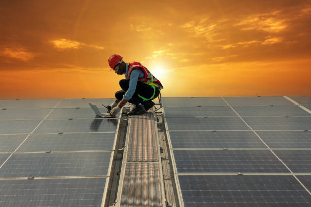 Engineer working setup Solar panel at the roof top. Engineer or worker work on solar panels or solar cells on the roof of business building stock photo