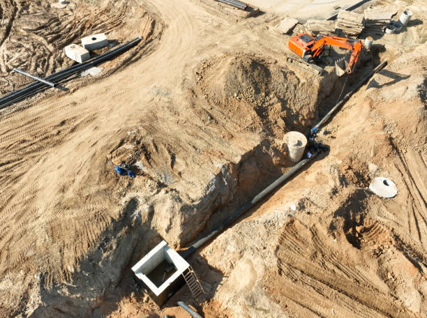 Sewage drainage system mounting at construction site. Excavator during laying sewer pipe and main systems. Sewage drainage system mounting at construction site. Excavator during laying sewer pipe and main systems. Civil infrastructure, water lines, sanitary sewers and storm sewers. Laying sewer pipes. truck in rain stock pictures, royalty-free photos & images