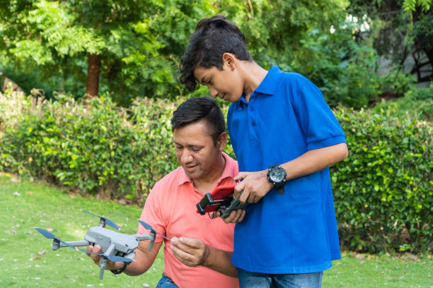 ojciec i syn latający dronem nad polem w okresie letnim - hector zdjęcia i obrazy z banku zdjęć