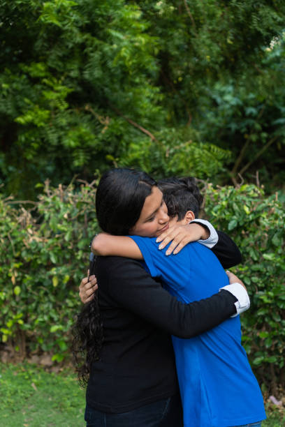 istock Two happy siblings laughing and hugging in a park 1404249278