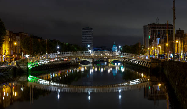 vue nocturne du célèbre pont illuminé ha penny à dublin, irlande - dublin ireland bridge hapenny penny photos et images de collection