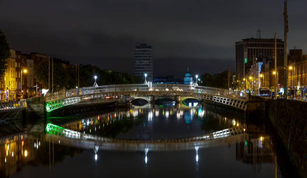 vista notturna del famoso ponte illuminato ha penny a dublino, irlanda - dublin ireland bridge hapenny penny foto e immagini stock