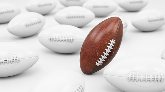 Brown American Football Ball Among White Copies. 3D Render