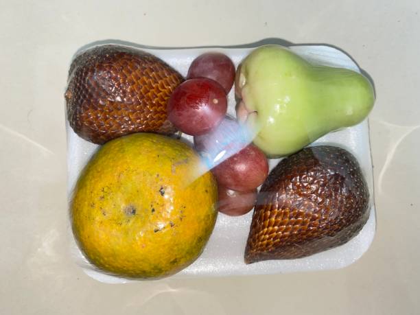 Fresh Fruit Pack Fresh fruit package consisting of grapes, snake fruit, guava and oranges. served at every formal and non-formal occasions. avocado brown stock pictures, royalty-free photos & images