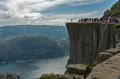 Lysefjord, Norway - May 21, 2022: Tourists on Preikestolen rock (Pulpit rock) - natural Norwegian landmark.