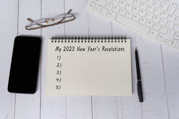 istock 2023 New Year's Resolutions text on notepad on wooden desk. Copy space. 1404257726