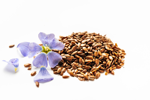 Flax seed and flax flowers macro on white backgrounds. Omega 3 fats. Superfood concept
