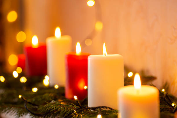 istock Line of burning candles on some fir-tree branches 1404259090