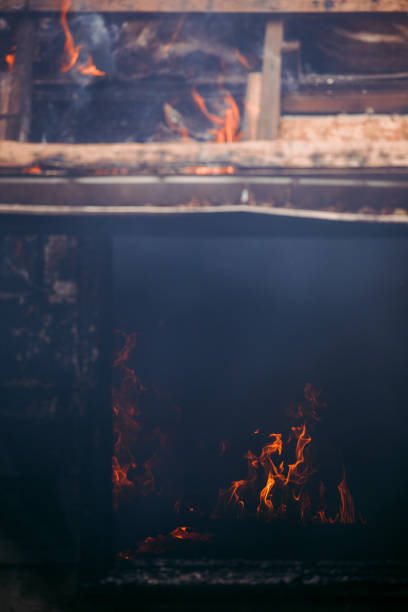 A burning home living room viewed through a smoldering window.