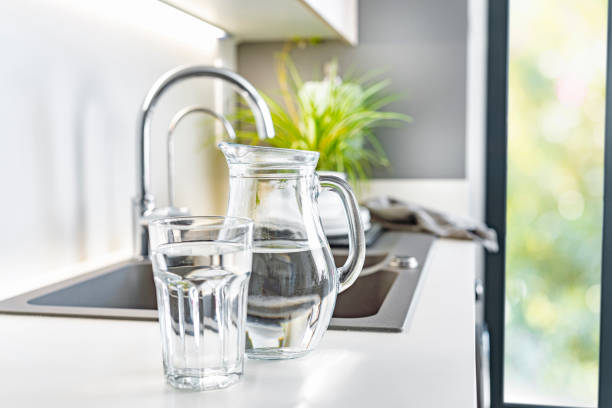 istock Close up of water glass and pitcher on kitchen counter 1404260809