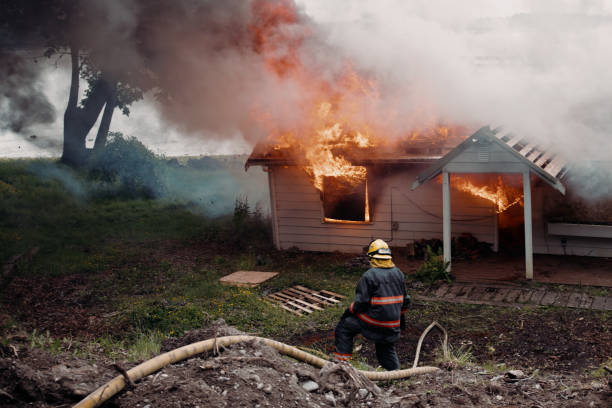 istock Female Firefighter Carrying Hose To Burning House 1404260841