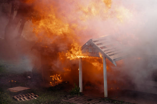 A burning unrecognizable home fully engulfed in raging flames.