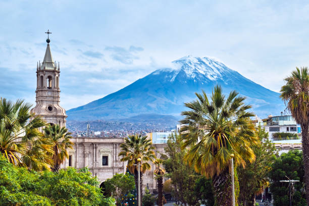 Tower on the background of a volcano in Arequipa, Peru. View from the central square on the volcano in Arequipa, Peru. arequipa province stock pictures, royalty-free photos & images