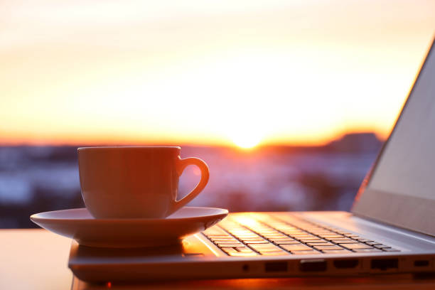 istock Coffee or tea cup on laptop against the window in sunshine 1404266543