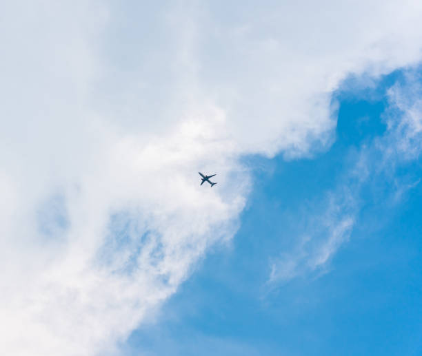 istock Airplane flying in the sky with white clouds 1404266945