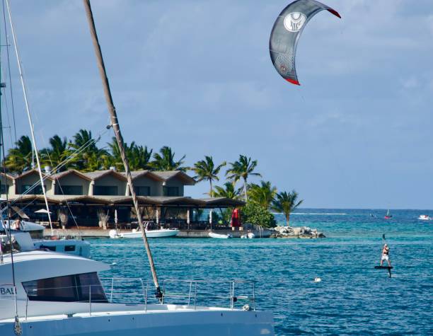 Saba Rock British Virgin Islands Saba Rock Island BVi april 2022 A Kiteboarder sails around the moored catamarans of the Island of Saba Rock , British Virgin Island kite sailing stock pictures, royalty-free photos & images