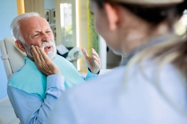 Mature man at dentist making painful face