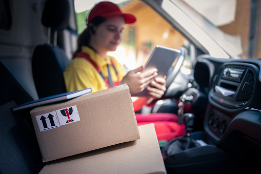 Delivery woman in her vehicle arriving to the adress.