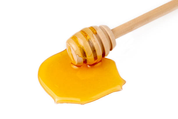 istock Honey with honey dipper isolated on white background. 1404269410