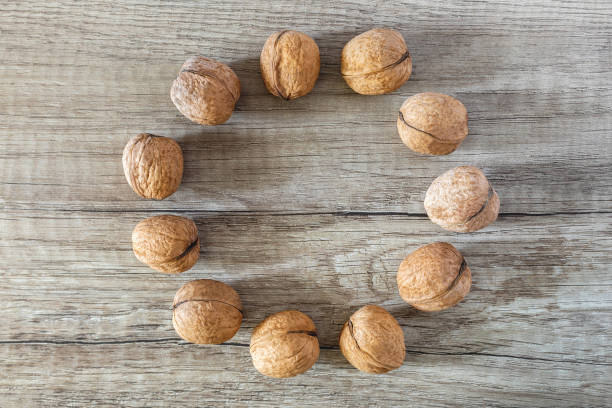 istock A circle of whole walnuts on a brown wooden background 1404271080
