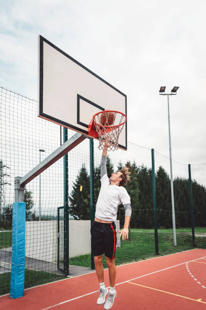 istock Young caucasian man jumping and making a slam dunk 1404271998