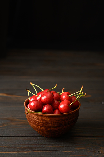 Sweet fresh cherry on a dark wooden background.